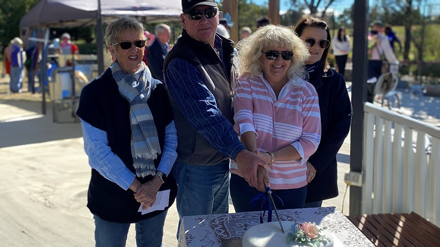 Four people cutting a cake to celebrate 75 anniversary of Texas Hospital Auxiliary.