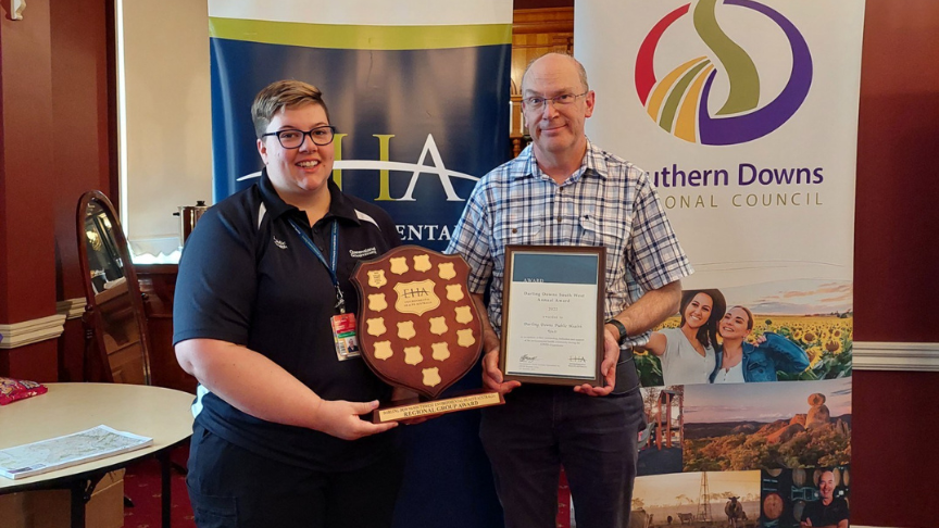 Staff members Rebecca Gibbons and Peter Boland holding certificate and award shield