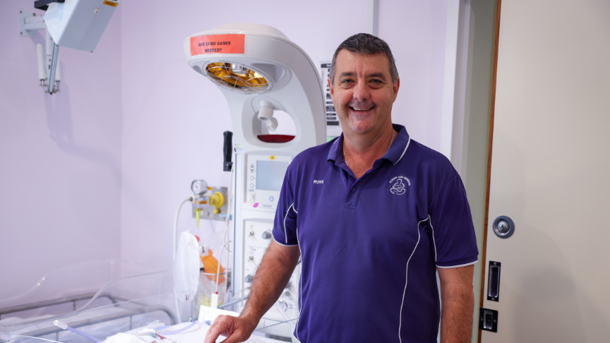 Male nurse standing in front of medical equipment